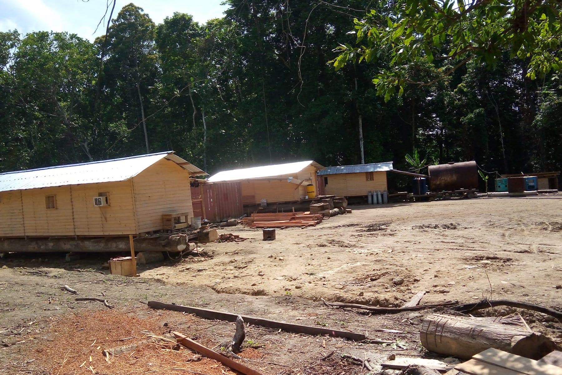 Group of wooden huts in a forest clearing